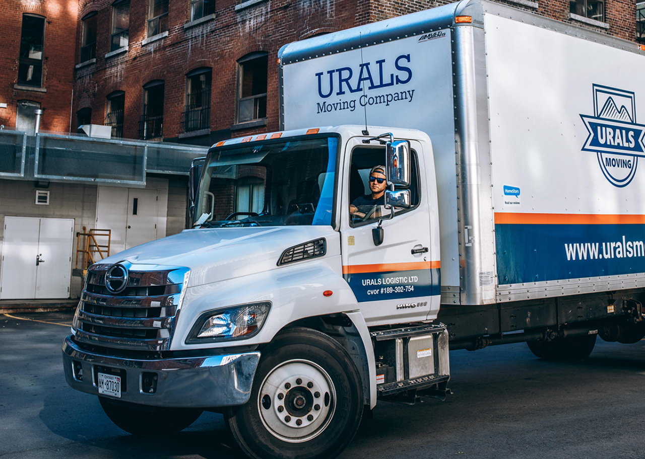 Urals Moving Company team with front of white truck